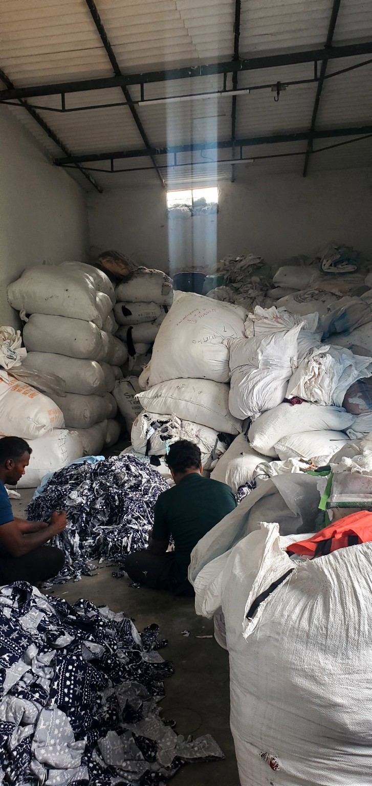 Packed cotton waste bales and bags in warehouse